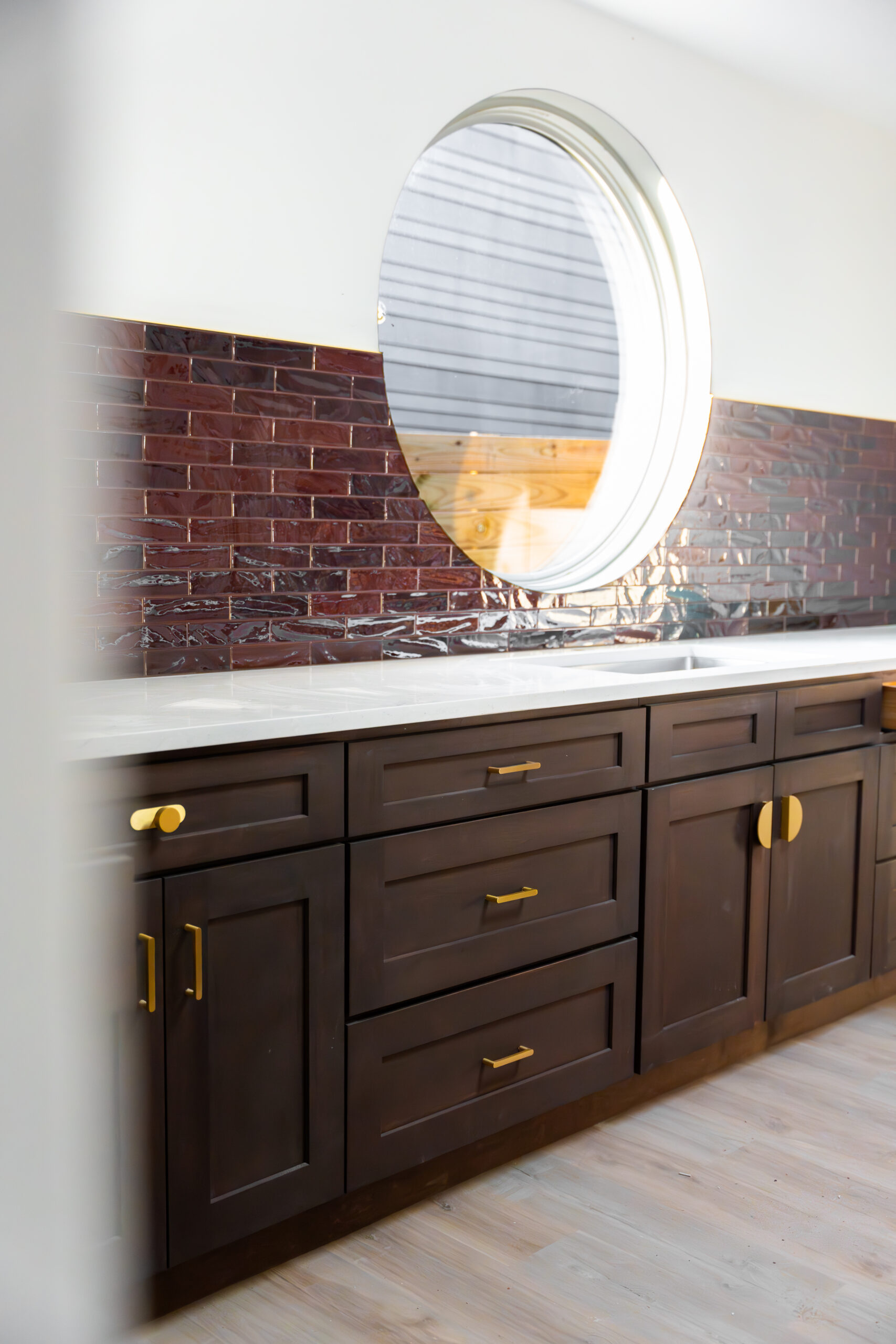 brown cabinets with brick tile